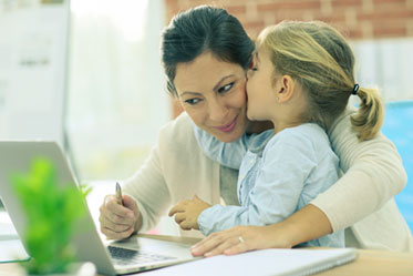 Vergrößerungsansichten für Bild: Eine Mutter mit Kind am Laptop.
