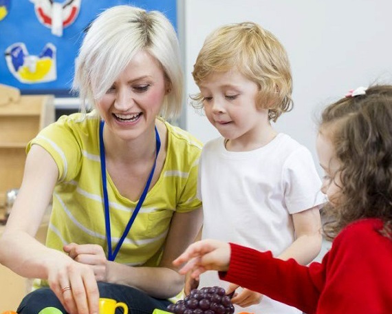 Erzieherin spielt mit zwei Kita-Kindern