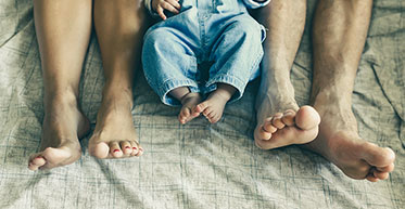 Nahaufnahme: Füße von Mutter, Kind und Vater