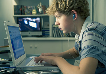 Vergrößerungsansichten für Bild: Am Schreibtisch: Junge am Laptop. 