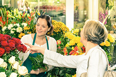 Vergrößerungsansichten für Bild: Verkäuferin mit Kundin in einem Blumengeschäft.