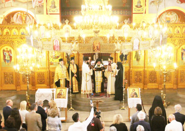 Mehrere Personen der griechisch-orthodoxen Kirche stehen in einer Gruppe zusammen. 
