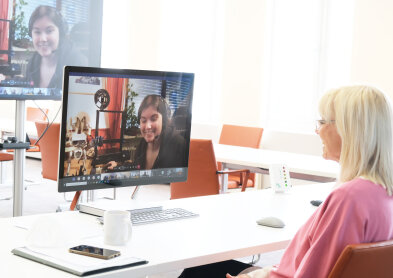 Staatsministerin Carolina Trautner vor einem Bildschirm sitzend in einer Video-Konferenz