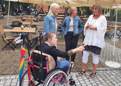 Auf dem Bild ist Sozialministerin Carolina Trautner mit drei Frauen zu sehen. Eine von ihnen sitzt im Rollstuhl. 