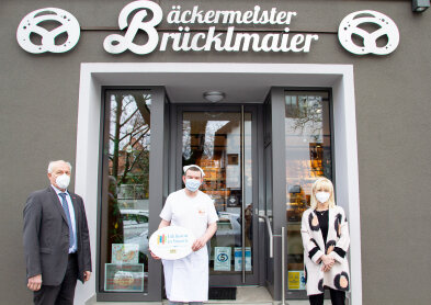 Staatsministerin Trautner zusammen mit den Emblemempfängern vor dem Eingang der Bäckerei Brücklmaier