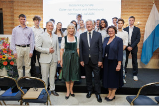 Das Bild zeigt von links nach rechts: Cornelius von der Heyden (Oberstudienrat des Gabriel-von-Seidl-Gymnasiums Bad Tölz), Staatsministerin Ulrike Scharf, Christian Knauer (Landesvorsitzender des Bunds der Vertriebenen Landesverband Bayern e. V.), Dr. Petra Loibl (Beauftragte der Bayerischen Staatsregierung für Aussiedler und Vertriebene)  sowie Schülerinnen und Schüler der 11. Jahrgangsstufe des Gabriel-von-Seidl-Gymnasiums Bad Tölz