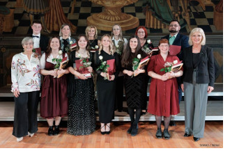 Das Foto zeigt Bayerns Sozialministerin Ulrike Scharf mit den Jahrgangsbesten
