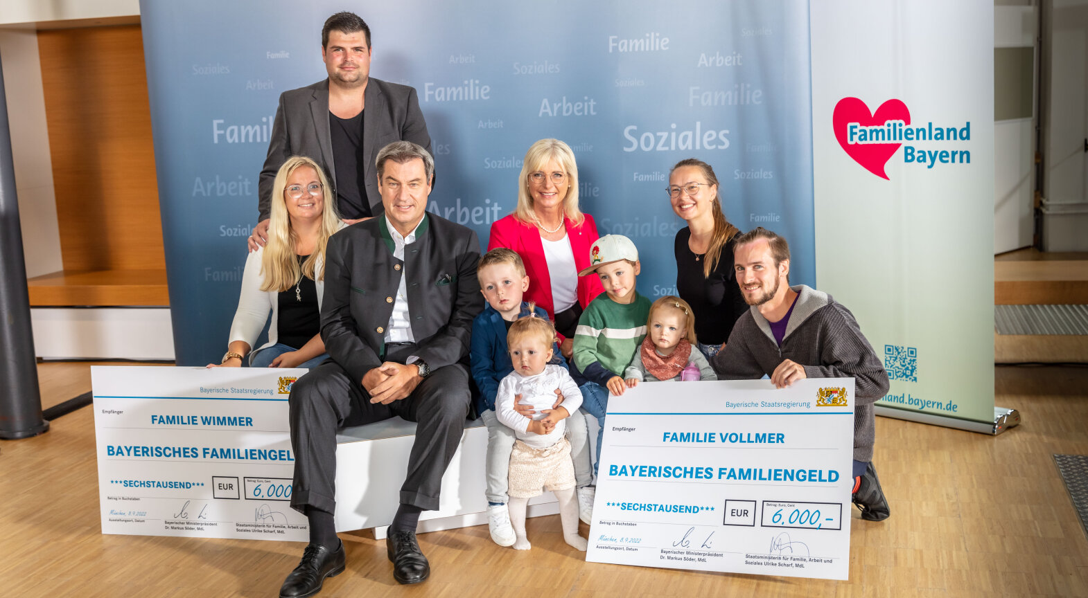 Die Fotos zeigen Ministerpräsident Dr. Markus Söder und Familienministerin Ulrike Scharf zusammen mit den Familien bei der Scheckübergabe.