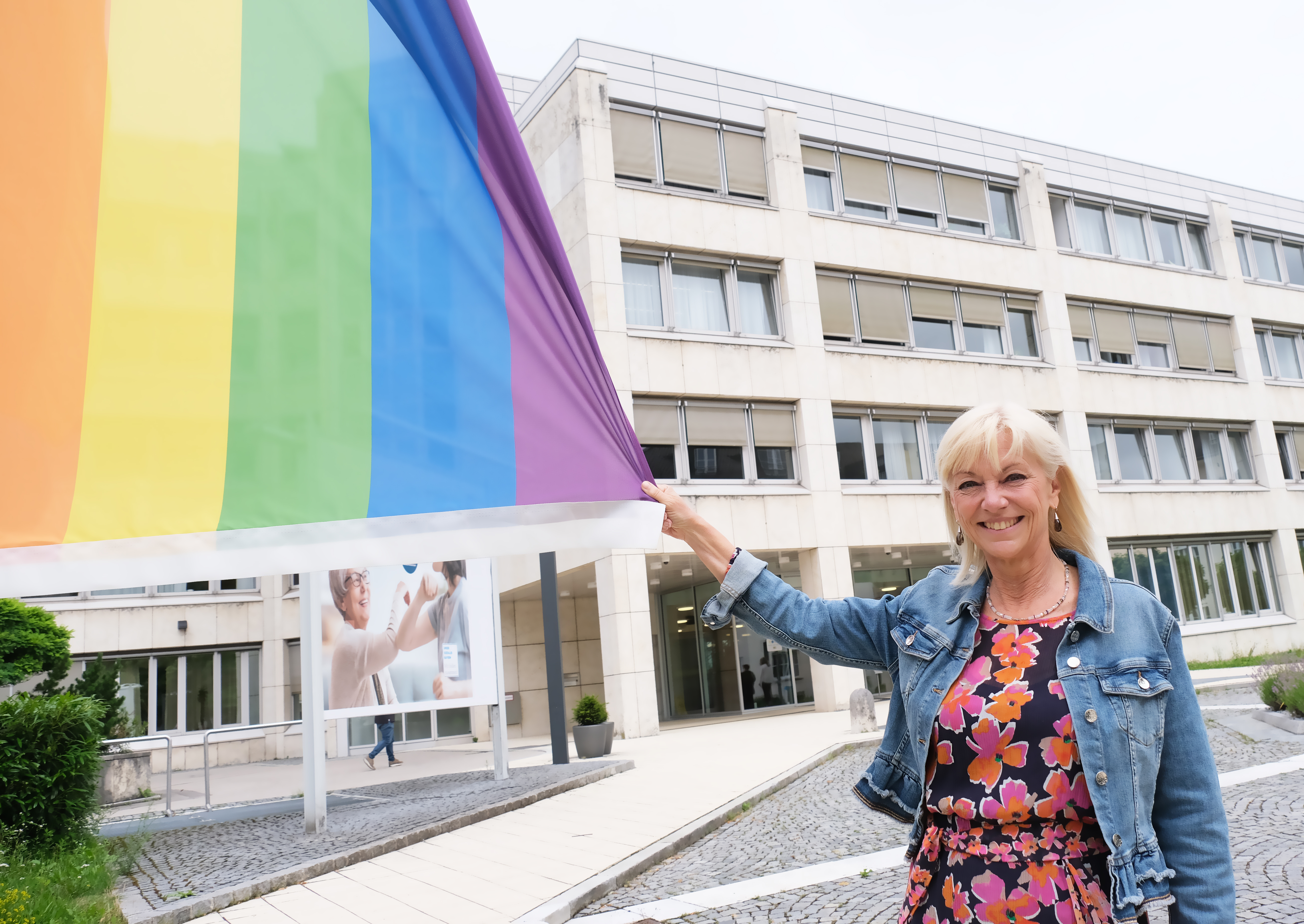 Foto Ministerin Trautner mit der Regenbogenflagge vor dem StMAS