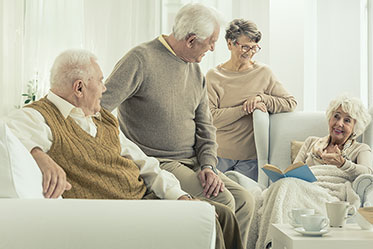 Gesprächssituation: Gruppe von älteren Menschen an einem Tisch.